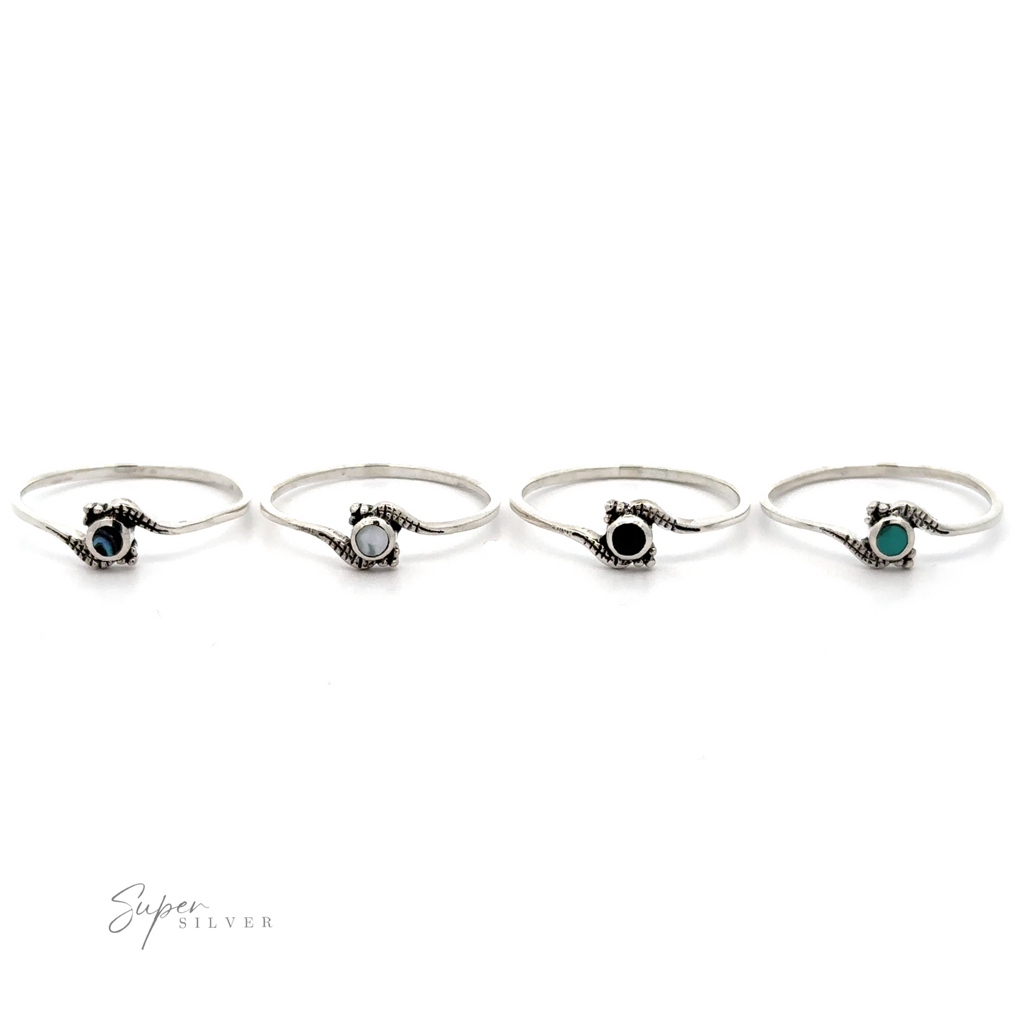 
                  
                    Four Tiny Freeform Rings with centered round turquoise gemstones on a white background.
                  
                