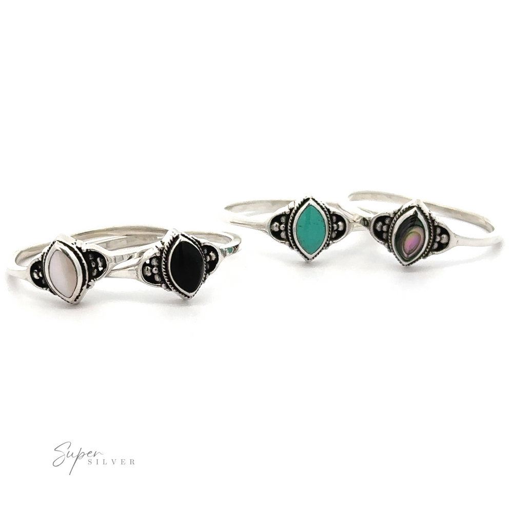 Three Delicate Marquise Inlaid Stone Rings with black, white, and green stones.