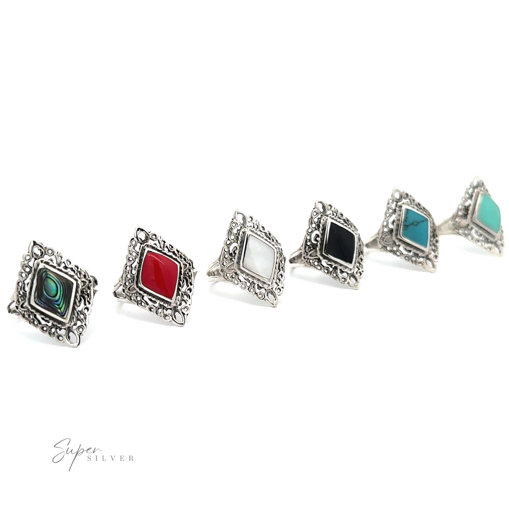A row of Diamond Shaped Filigree Rings with Inlaid Stones in different colors.