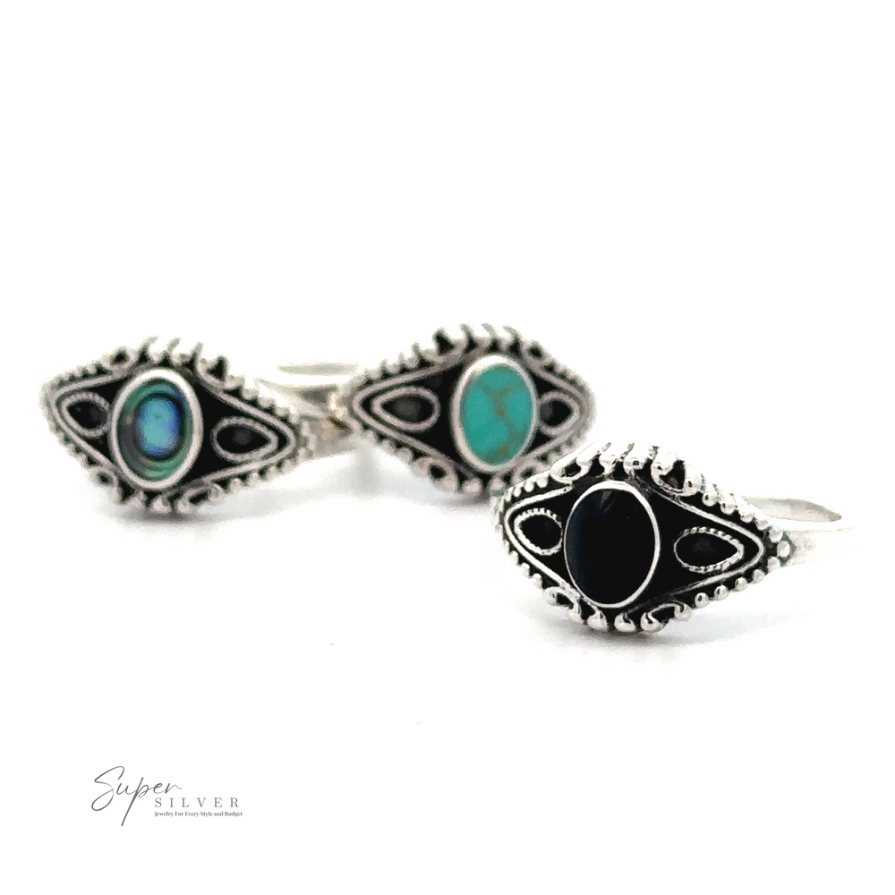 Three silver rings with intricate designs, each featuring a different inlaid stone: one black, one turquoise, and one in blue and green. Crafted from .925 Sterling Silver, these Vintage Style Rings With Inlaid Oval Stone showcase the 