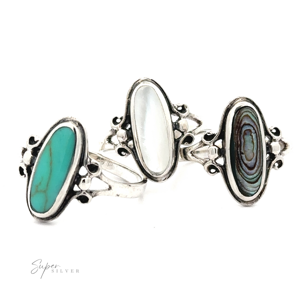 Three oval turquoise rings with inlaid abalone stones, featuring swirl detailing.
