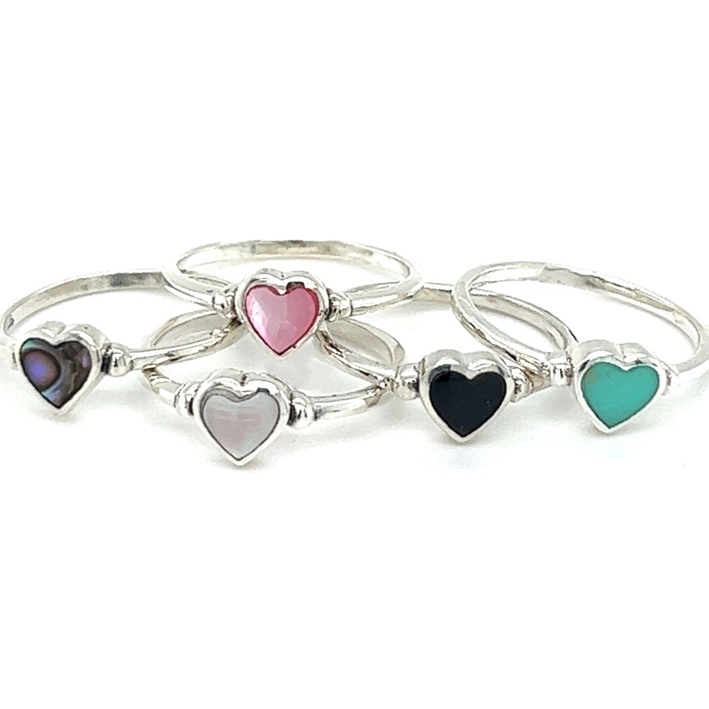 Four Dainty Inlaid Heart Rings with different colored inlaid stones.