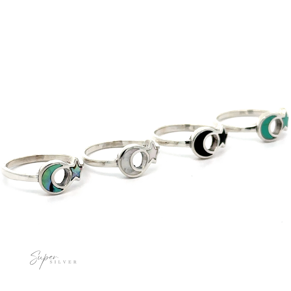 A set of four Crescent Moon And Star Rings with Inlaid Stones, displayed in a row on a white background.