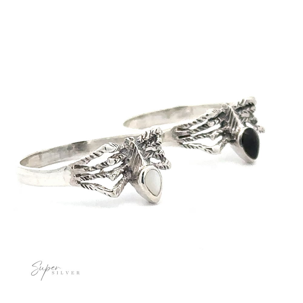 Two Small Inlay Spider Rings with intricate designs and small stones, one white and one black, photographed on a plain white background, exuding an aura of mystical jewelry.