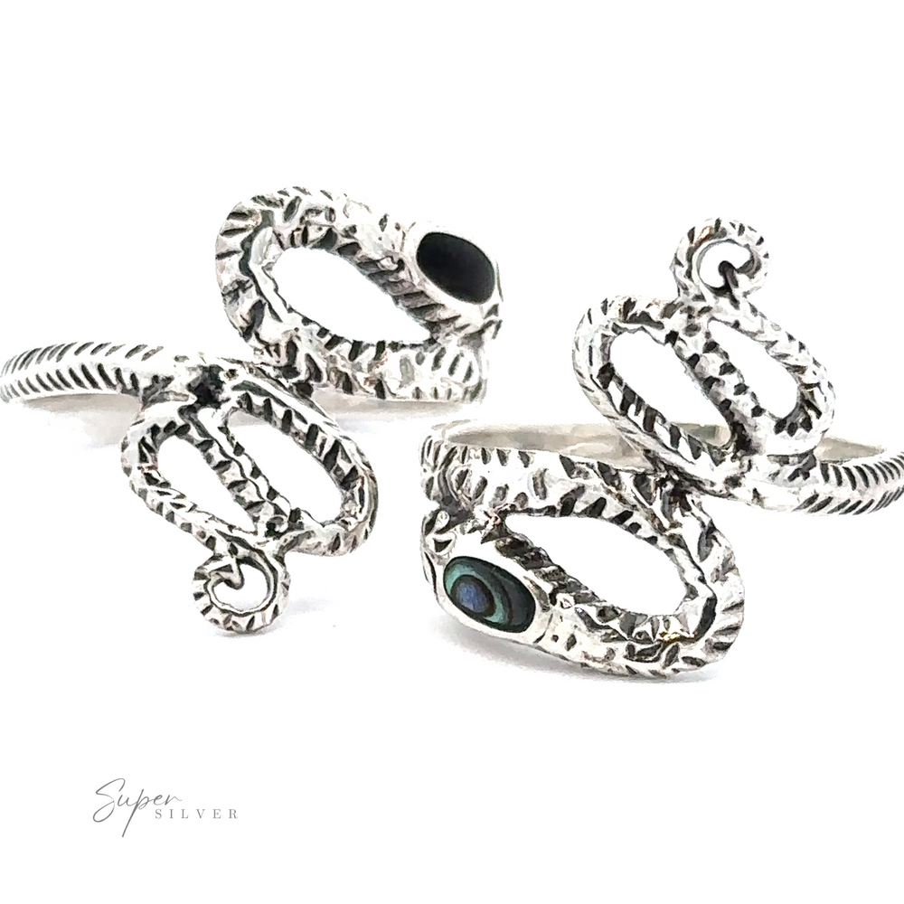 
                  
                    The Inlay Stone Snake Rings, crafted from sterling silver, showcase textured designs and dark stone accents, embodying a hint of gothic elegance.
                  
                