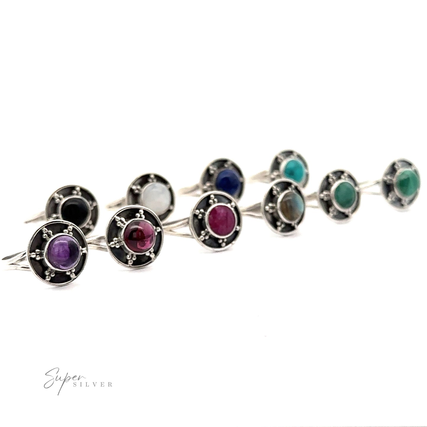
                  
                    A collection of nine Gemstone Rings With Unique Oxidized Design, each showcasing a different colored gemstone set in an oxidized silver circular mount, arranged in three rows against a white background.
                  
                