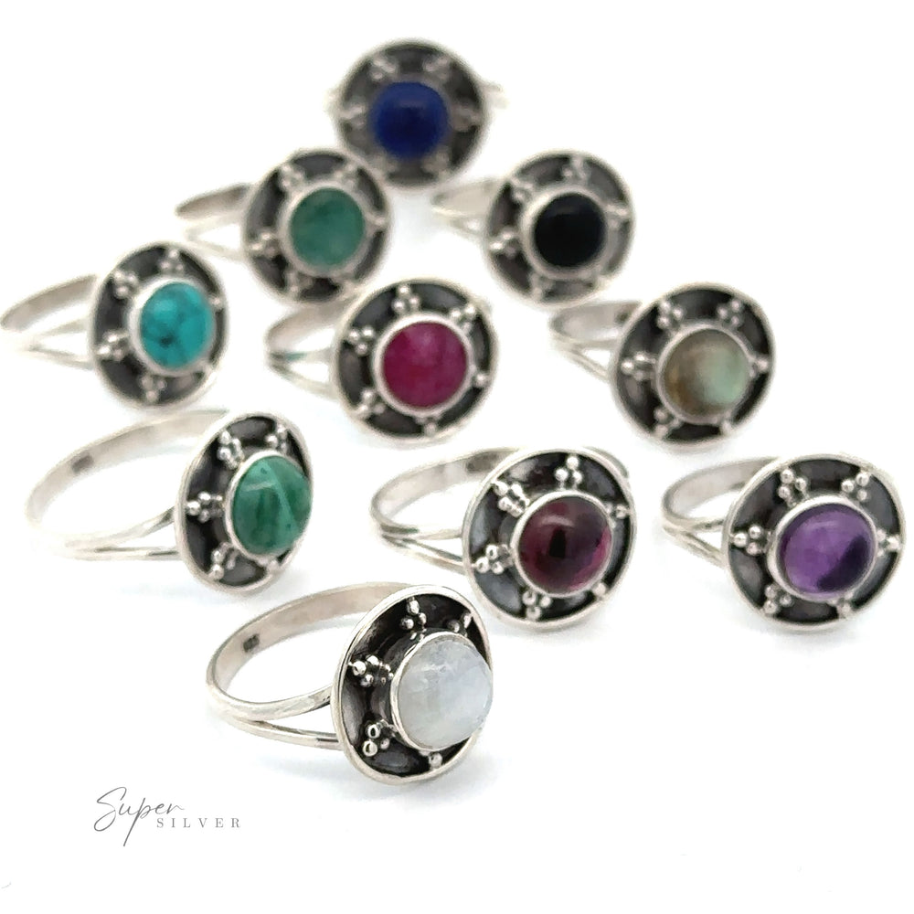 A collection of ten Gemstone Rings With Unique Oxidized Design, each featuring a different colored round gemstone in the center, arranged in two staggered rows against a white background.