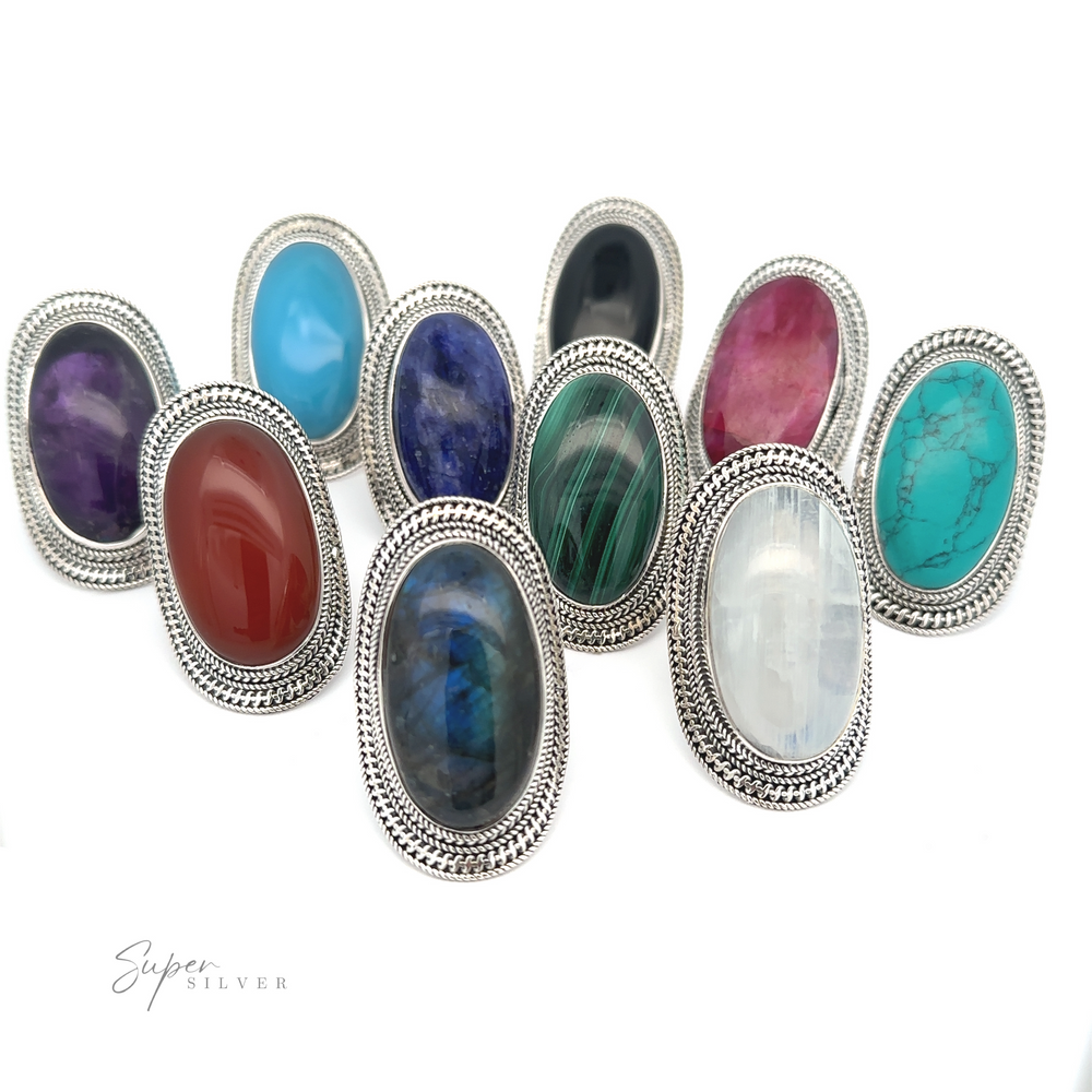 A Large Oval Shield Gemstone Ring with colorful oval gemstones, arranged in three rows. Each ring features intricate detailing around the gemstone, adding a touch of bohemian flair. Text at the bottom left reads "Super Silver.