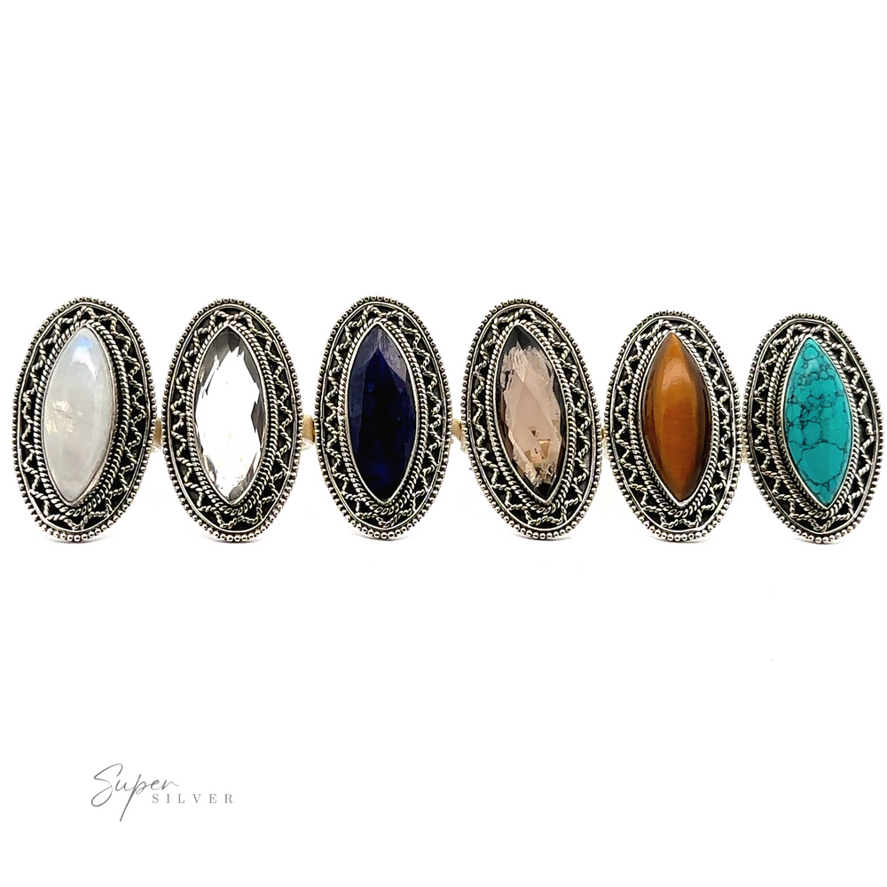 
                  
                    Six Marquise Shaped Gemstone Rings With Vintage Shield Borders, each featuring different gemstones: white, clear, dark blue, pale pink brown, and turquoise. A Bohemian twist adds a unique flair to these intricate designs.
                  
                