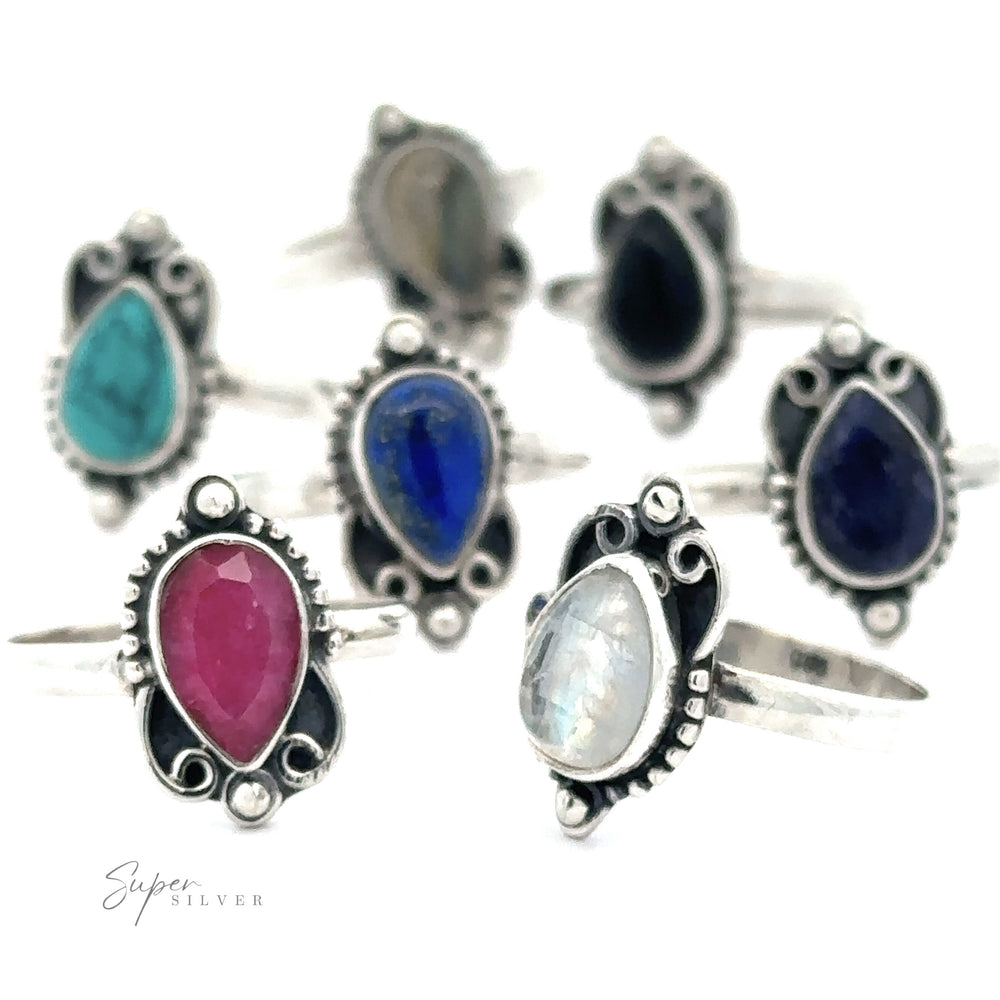A collection of Vintage Inspired Teardrop Gemstone Rings with various colored gemstones, each featuring intricate metalwork designs.