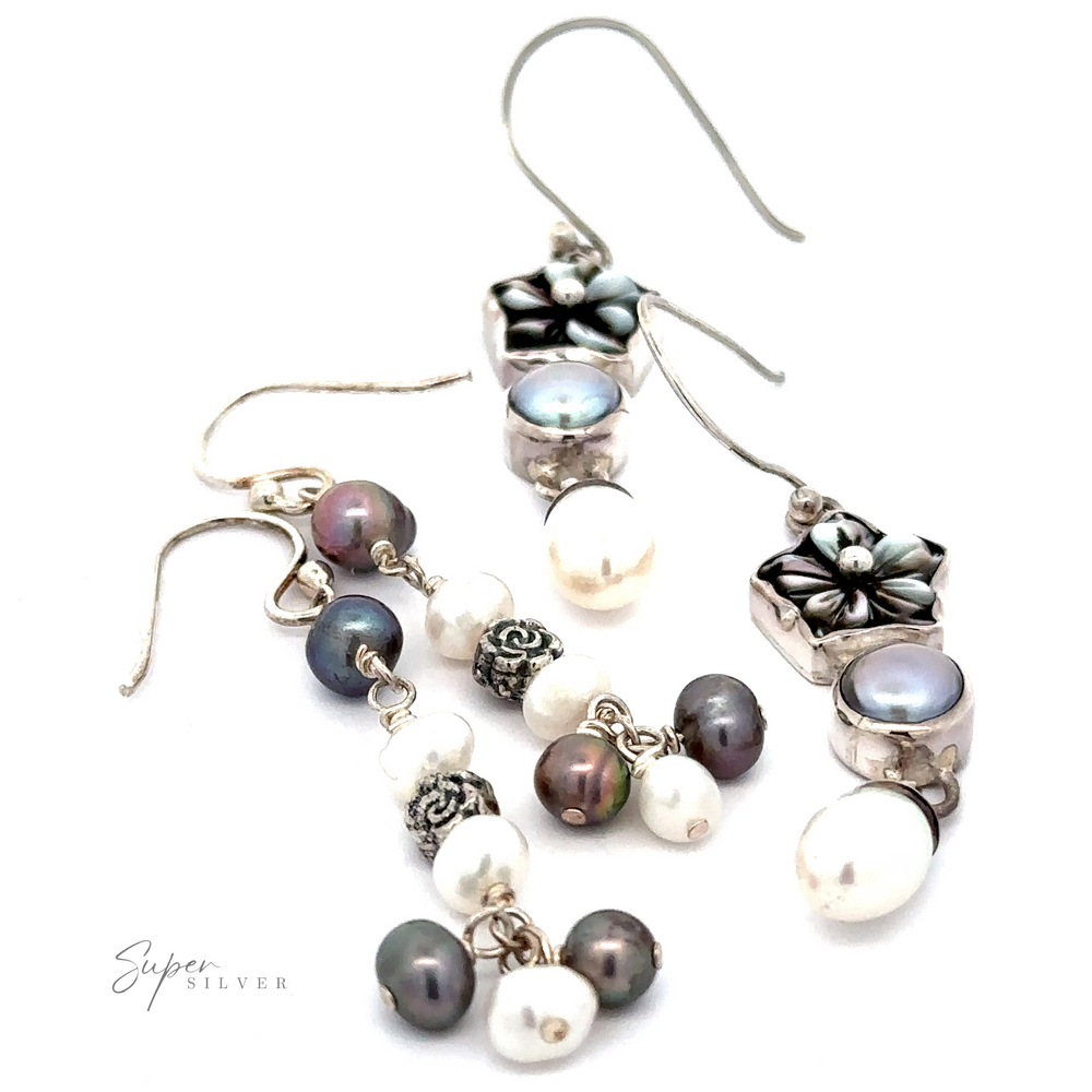 A pair of elegant sterling silver earrings featuring a floral design and adorned with white and dark pearls, these Floral Pearl Bead Earrings are beautifully displayed on a white background.