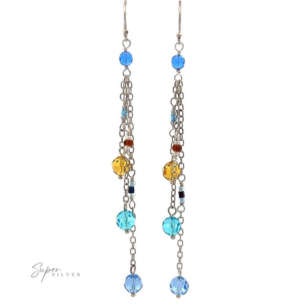 
                  
                    A pair of Multicolor Beaded Dangle Earrings with long chains featuring multicolored beads in blue, yellow, and brown. A small "Super Silver" logo is on the bottom left.
                  
                