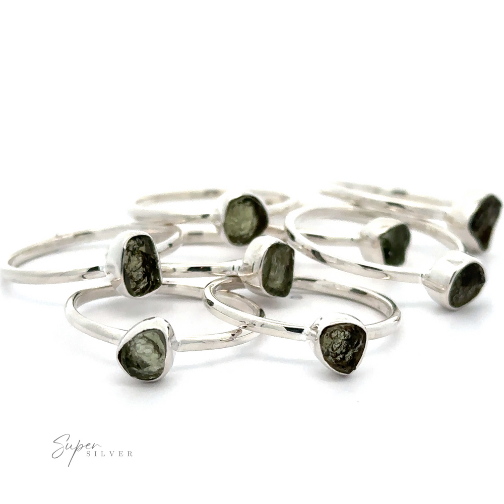 
                  
                    A collection of sterling silver rings with rough-cut green Raw Moldavite Rings, displayed against a white background.
                  
                