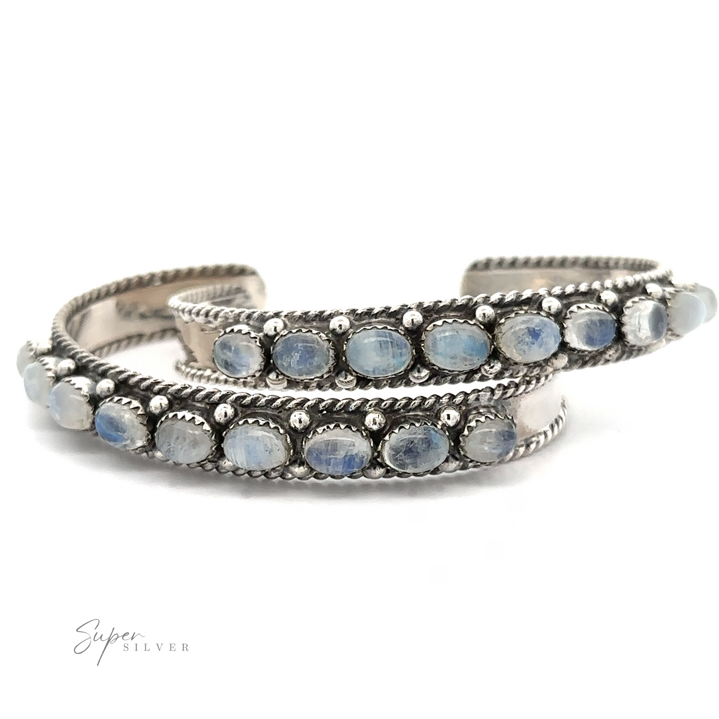 
                  
                    A silver Oval Moonstone Cuff Bracelet with two parallel bands adorned with oval blue stones set in bezels, finished with twisted rope detailing along the edges, believed to aid in emotional healing through its soothing metaphysical properties.
                  
                