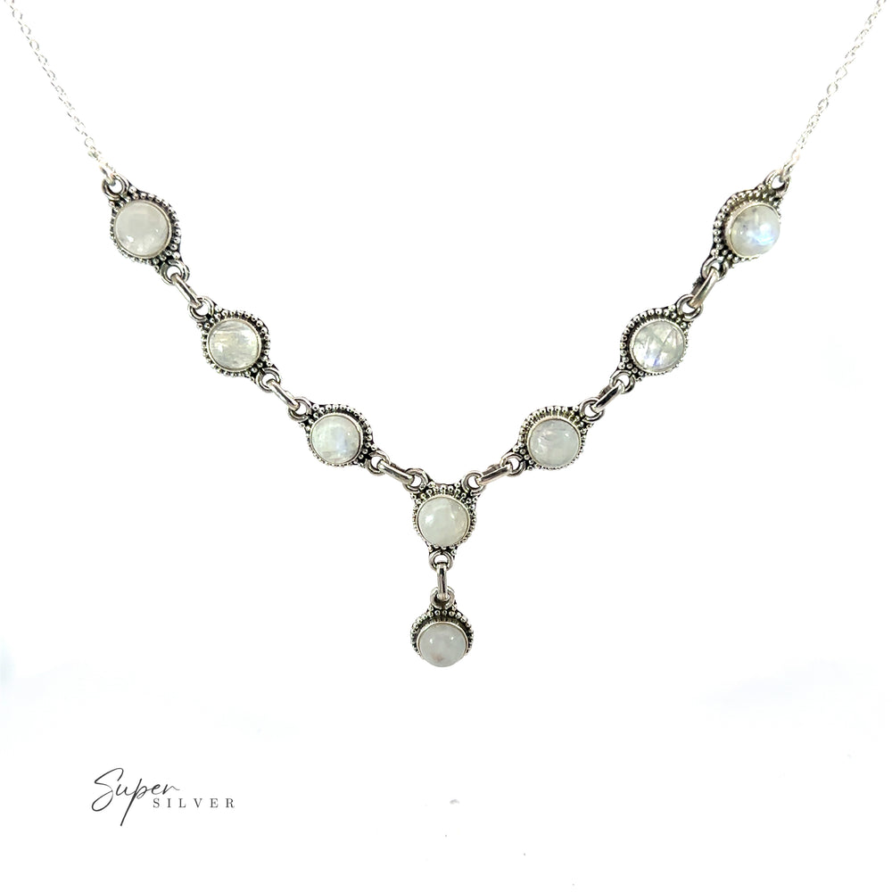 
                  
                    A delicate Round Gemstone Y Necklace with Ball Border featuring round, opaque stones arranged in a V-shape, with a small pendant at the center. This bohemian style jewelry piece showcases the brand name "Super Silver" elegantly written in the bottom left corner.
                  
                