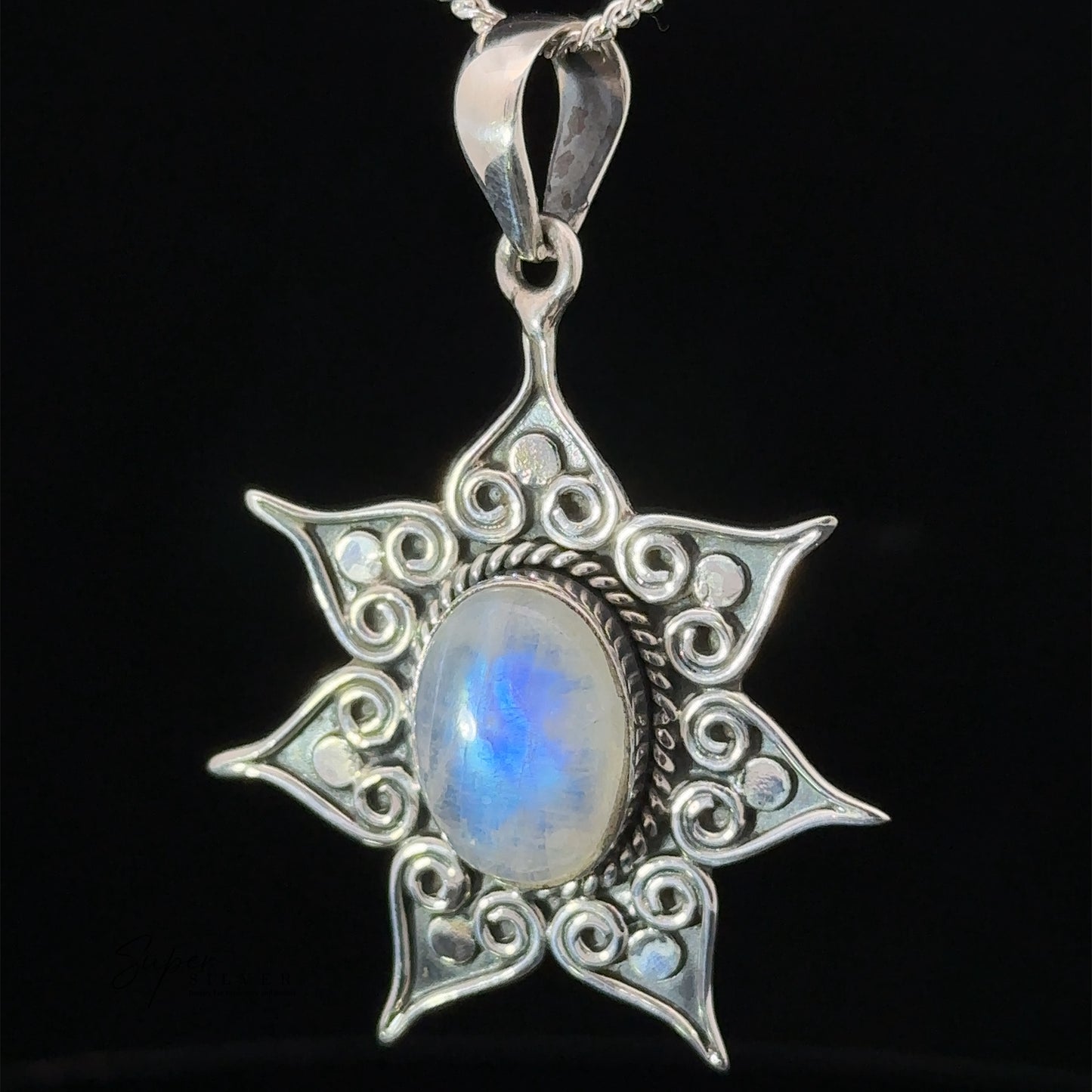 A Floral Design Gemstone Pendant with intricate swirls and a central oval moonstone, hanging on a sterling silver chain. This enchanting piece of moonstone jewelry also features a delicate flower star setting for added charm.