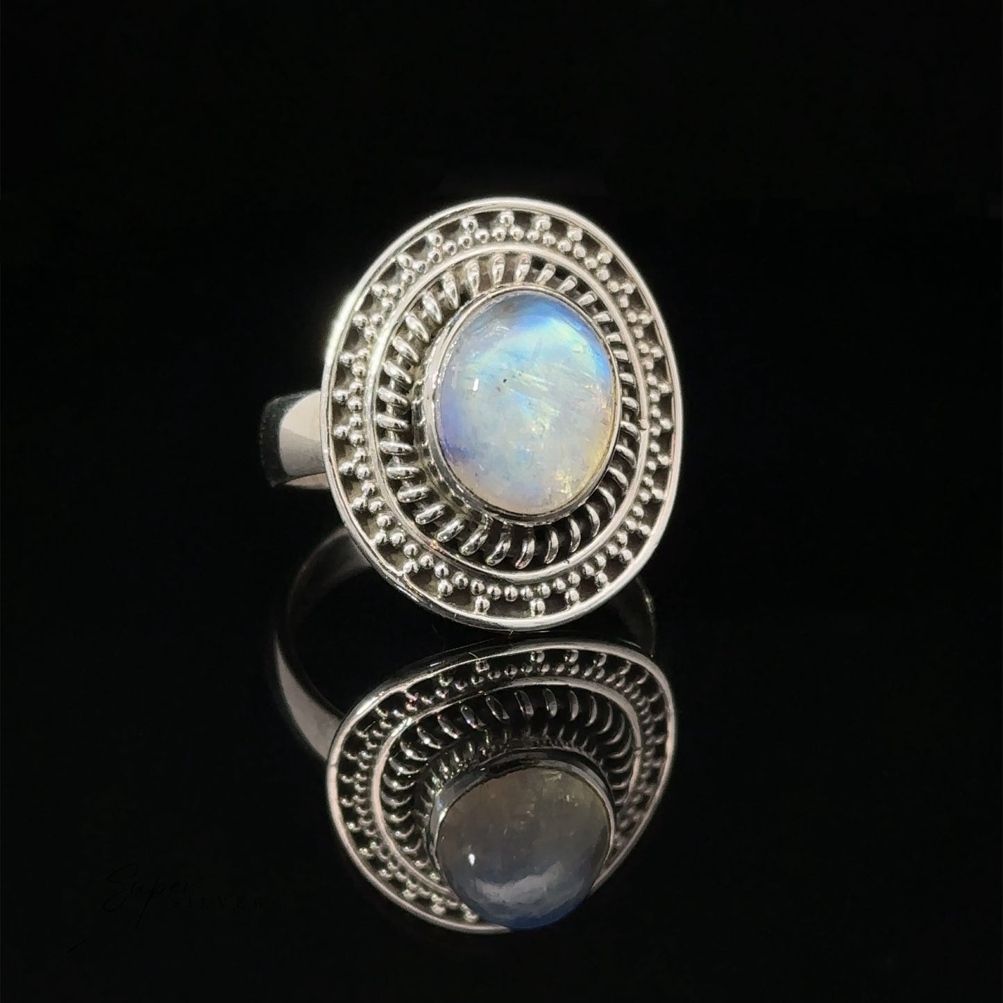 
                  
                    A moonstone ring with a braided disc design, displayed on a reflective black surface.
                  
                