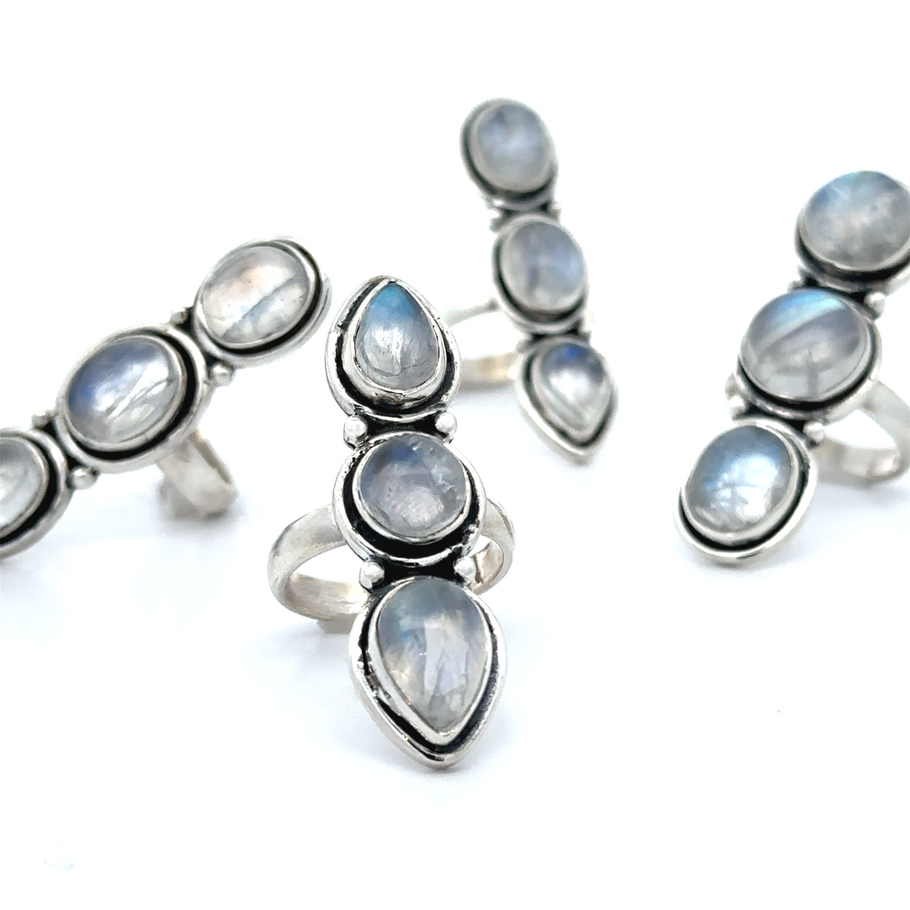 
                  
                    Five Triple Moonstone Rings, crafted in sterling silver and exuding a touch of goddess energy, are elegantly arranged on a white background.
                  
                