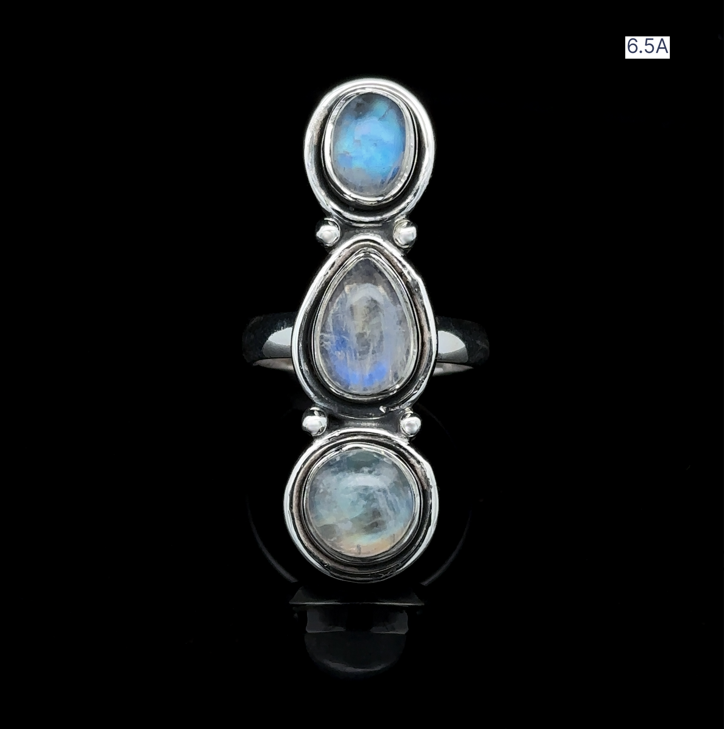 
                  
                    The Triple Moonstone Ring showcases three vertically stacked oval moonstones set against a black background, radiating goddess energy. Elegantly labeled in the top right corner is Size 6.5A.
                  
                