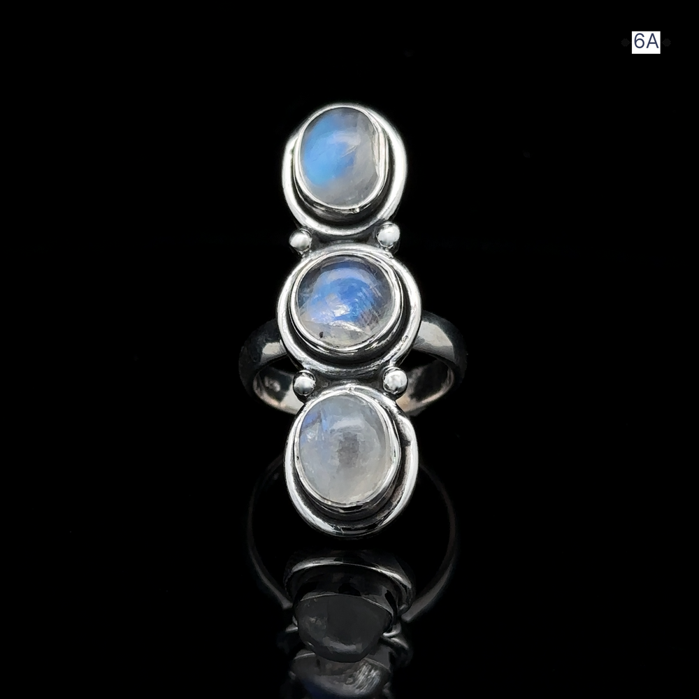 
                  
                    Triple Moonstone Ring crafted from sterling silver, showcasing three oval moonstone settings that exude goddess energy and a reflective surface, beautifully displayed against a black background.
                  
                