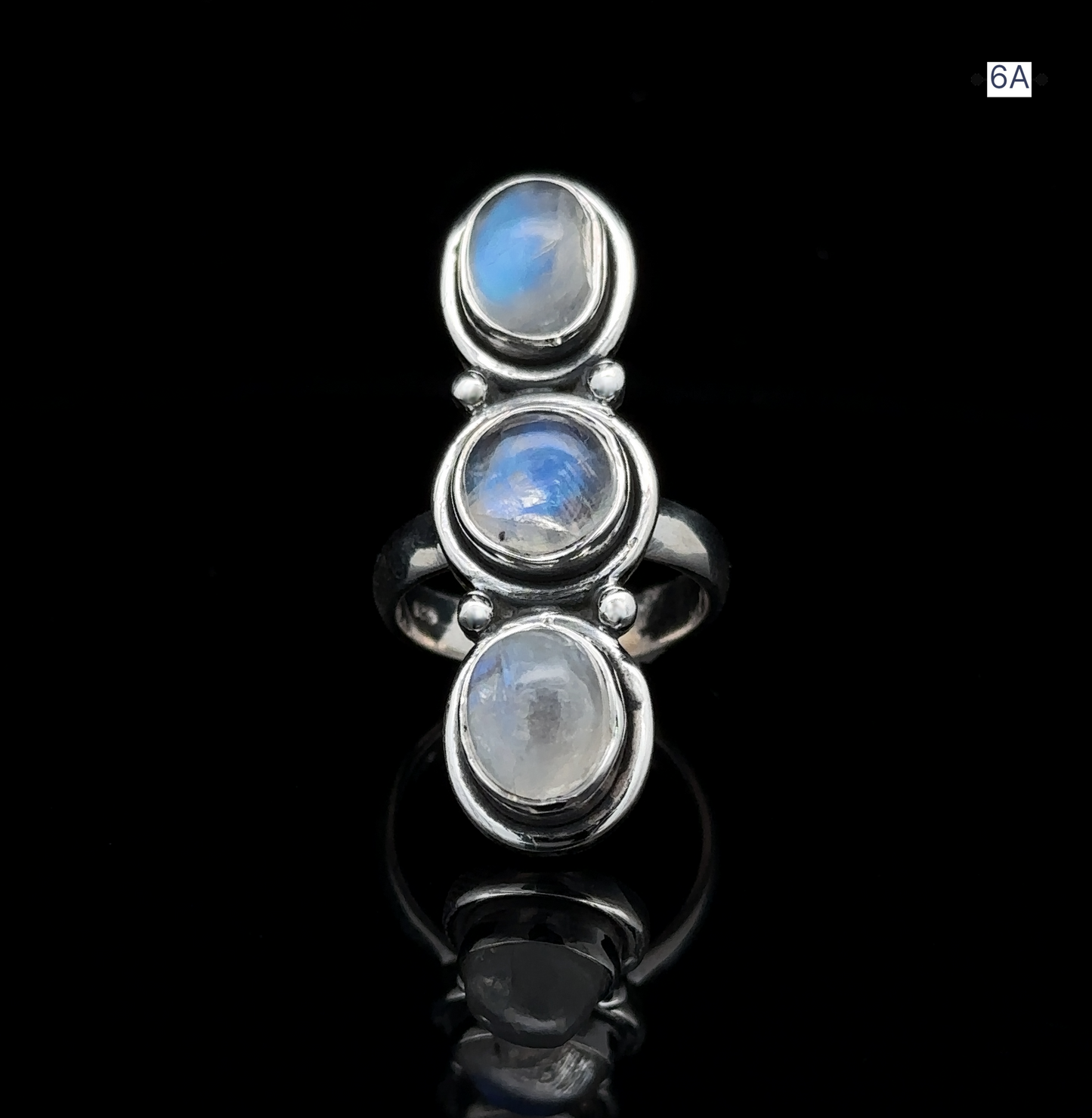 
                  
                    Triple Moonstone Ring crafted from sterling silver, showcasing three oval moonstone settings that exude goddess energy and a reflective surface, beautifully displayed against a black background.
                  
                