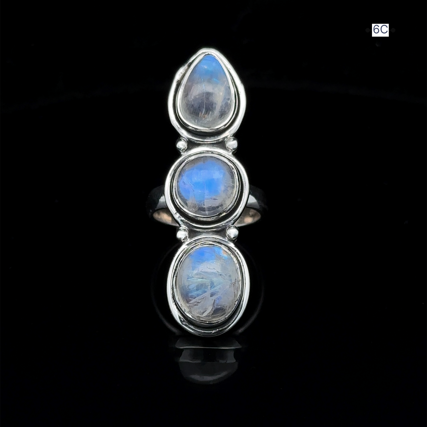 
                  
                    The Triple Moonstone Ring radiates goddess energy, showcasing three enchanting oval moonstone gems arranged in a vertical row against a sleek black background.
                  
                