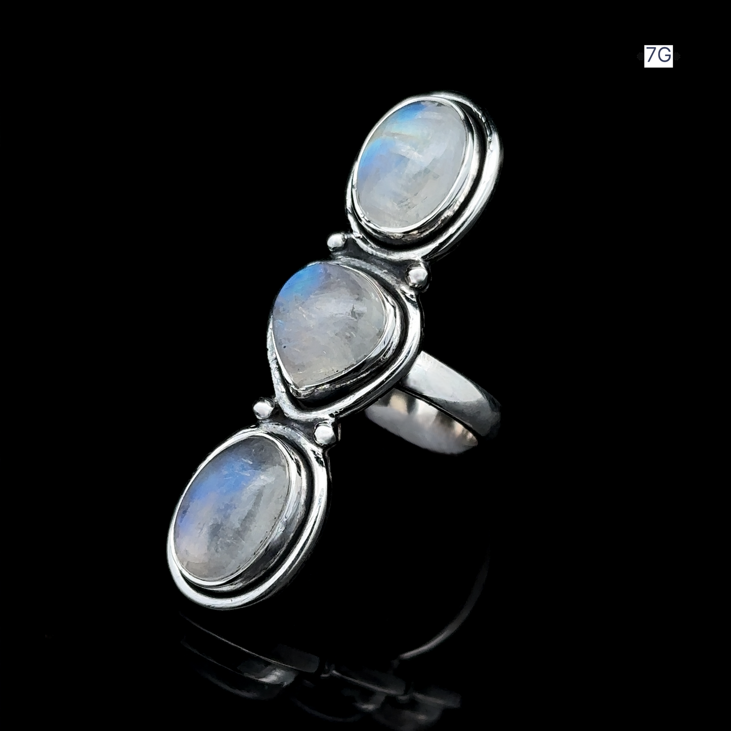 
                  
                    The Triple Moonstone Ring showcases three oval moonstone gems arranged vertically on a black background, embodying goddess energy.
                  
                