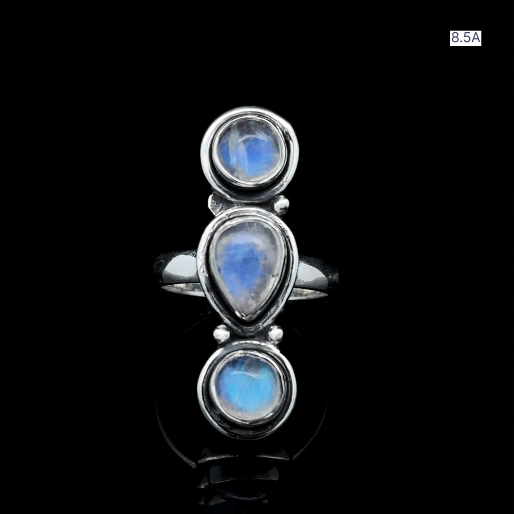 
                  
                    Triple Moonstone Ring crafted in sterling silver, featuring three gemstones in round and teardrop shapes, exuding goddess energy against a black background.
                  
                