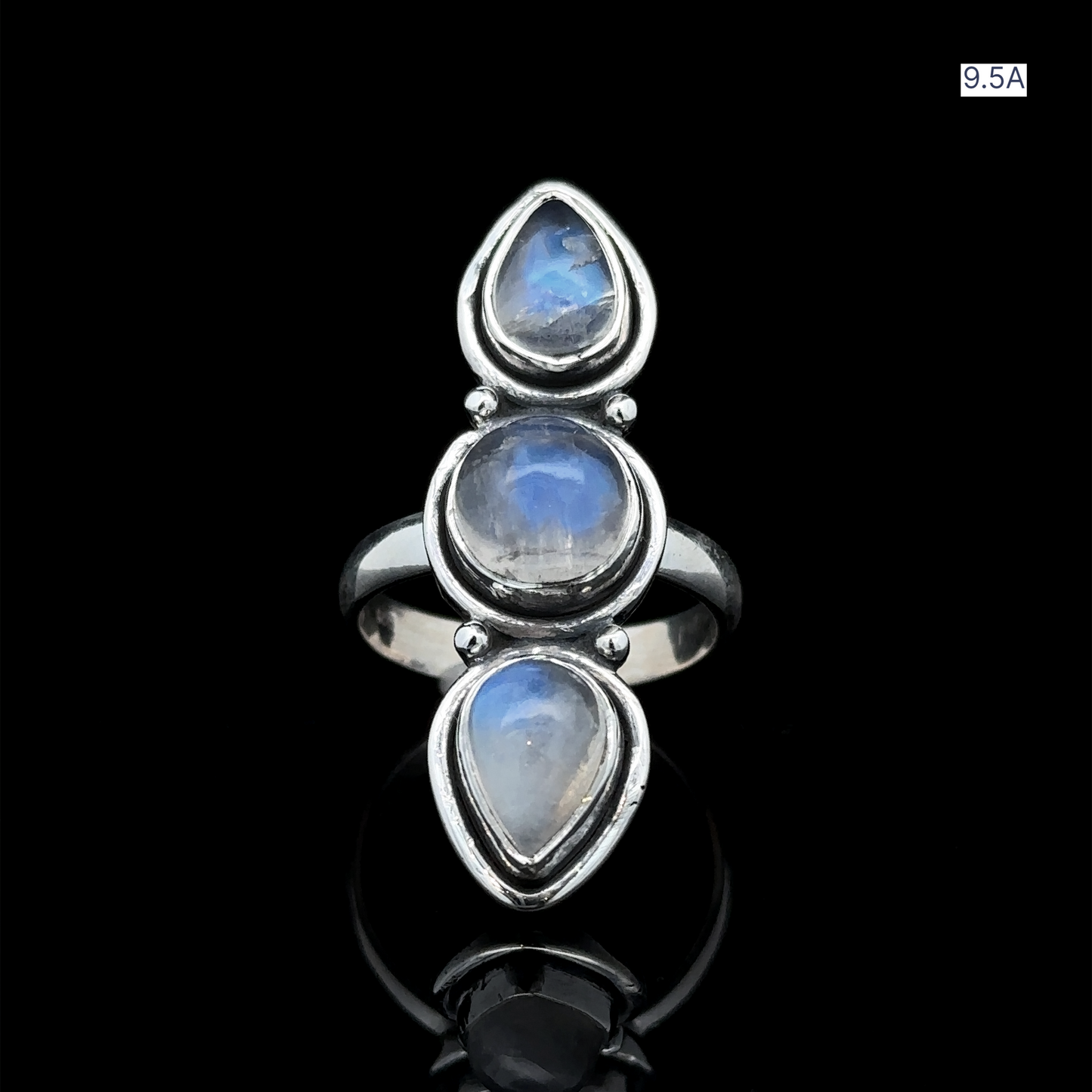 
                  
                    The Triple Moonstone Ring, crafted in sterling silver, showcases three oval moonstone cabochons that radiate goddess energy. Positioned vertically against a black backdrop, this ring is available in size 9.5A.
                  
                