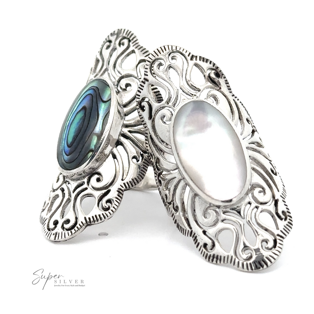 Two intricately designed silver rings, one featuring an abalone shell and the other a white pearl, showcased on a white background exuding vintage charm. The name "Long Vintage-Inspired Filigree Ring With Inlaid Stone" is printed at the lower left corner, highlighting these pieces of standout jewelry.