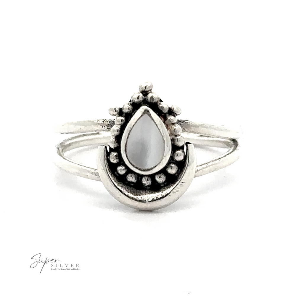 
                  
                    A Teardrop Ring With Inlaid Stone and Crescent Moon featuring a teardrop-shaped white stone in the center, surrounded by small decorative metal beads, with a minimalist split band design. This bohemian ring is adorned with Bali-inspired silverwork, adding an exotic touch to its elegant simplicity.
                  
                