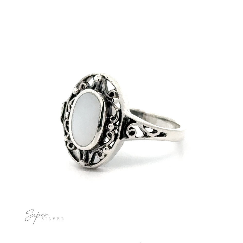 
                  
                    An ornate sterling silver ring with an Oval Inlay Stone with Swirl Filigree Border.
                  
                