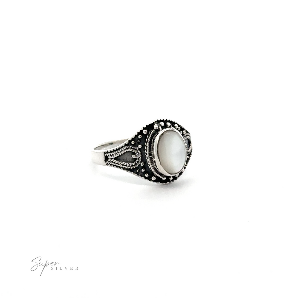 
                  
                    A vintage-chic Vintage Style Oval Shield Ring with Inlaid Stones adorned with a white mother of pearl, exuding bohemian charm and a rustic look.
                  
                