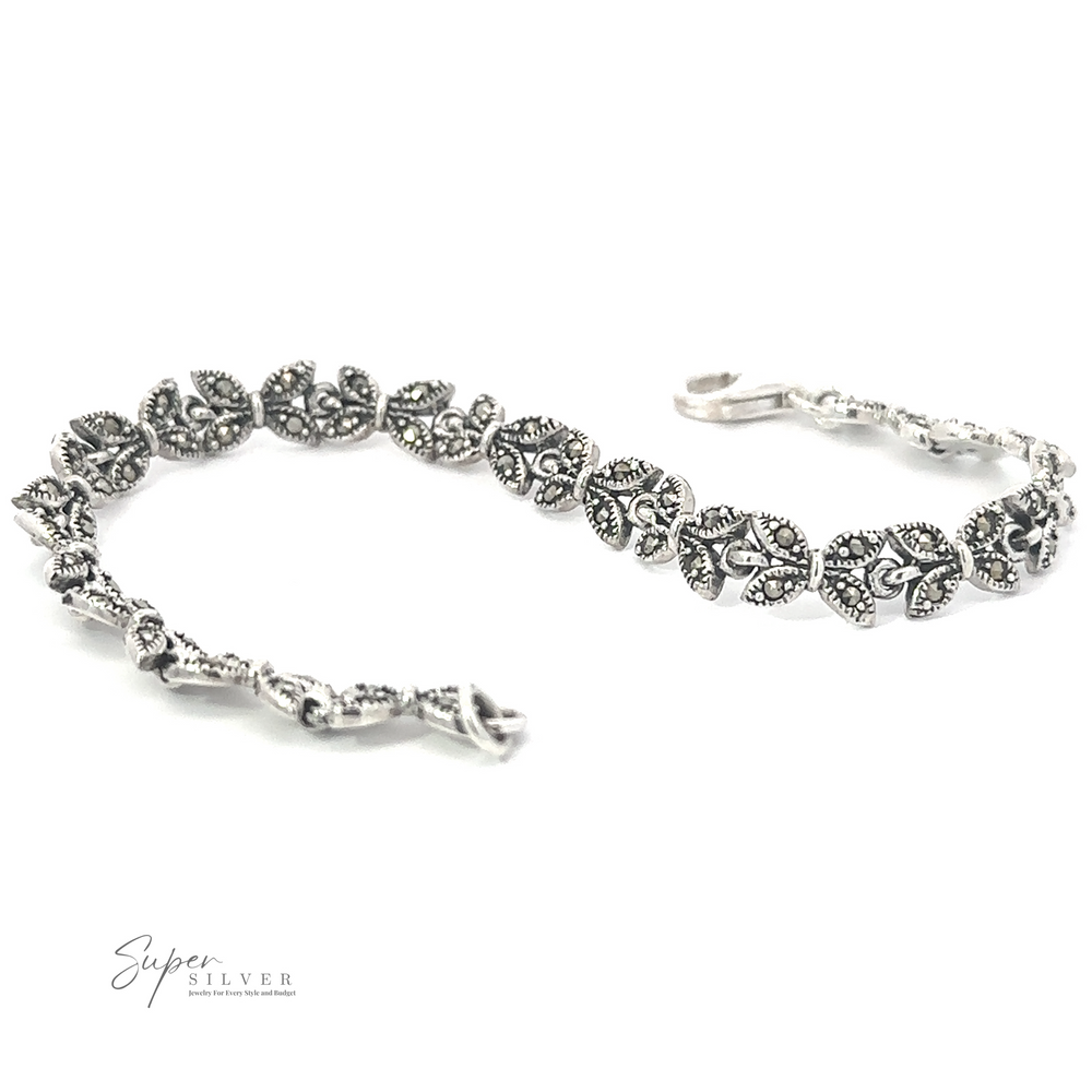 
                  
                    A Marcasite Butterfly Bracelet featuring intricate leaf designs with detailed floral patterns, reminiscent of the Art Deco era. Crafted from .925 sterling silver, it has a touch of vintage charm. A small logo, "Super Silver," is visible in the bottom left corner.
                  
                