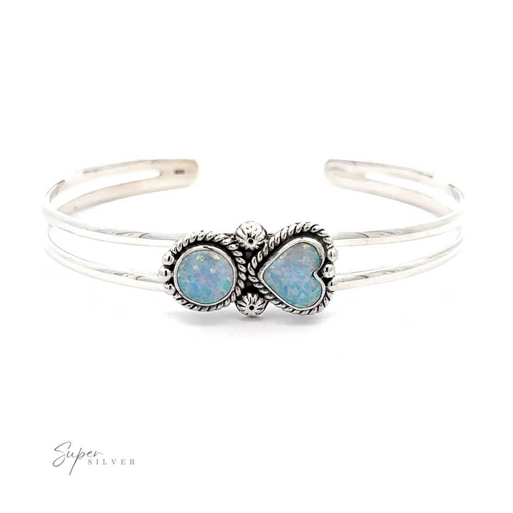 A Opal Heart And Circle Cuff Bracelet featuring two oval opal stones set in intricately designed bezels. The band is split into two parallel sections that merge at the settings, giving it a romantic jewelry appeal. Text reads 