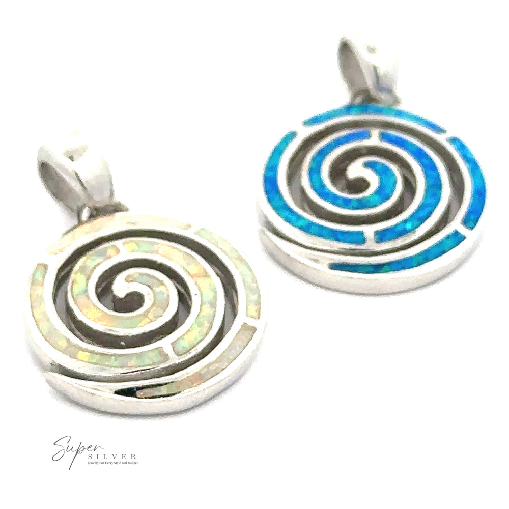 Two round silver pendants with elegant spiral designs are shown. One Opal Spiral Pendant features a blue swirl pattern, while the other showcases a green swirl design. With a refined rhodium finish, both pendants exude sophistication. The logo "Super Silver" appears in the bottom left corner.