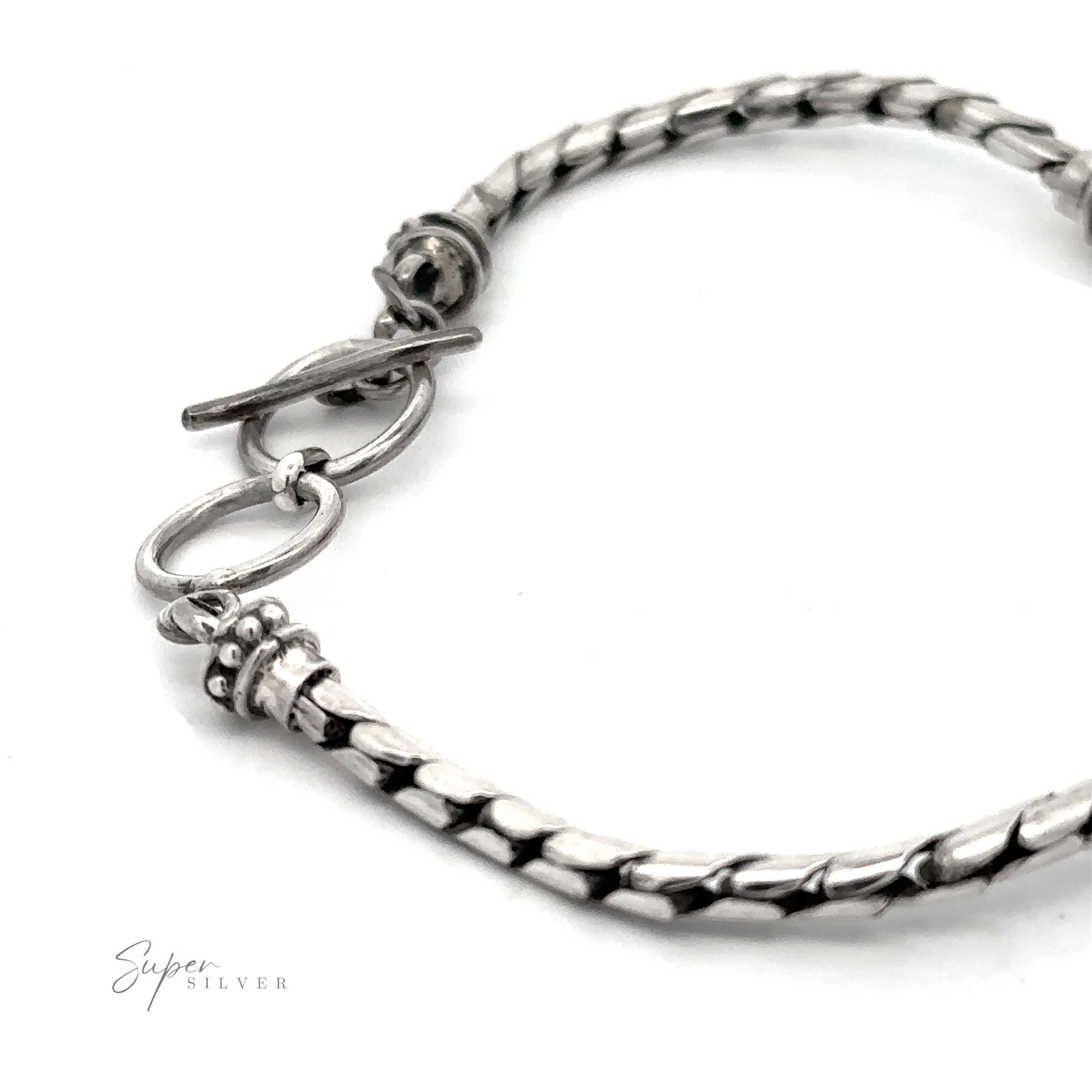 A close-up image of a Blue Mabe Pearl Bali Bracelet with a toggle clasp. The bracelet has a textured, woven design and the brand "Super Silver" is seen in the bottom left corner, reflecting the artistry of Bali crafted jewelry.