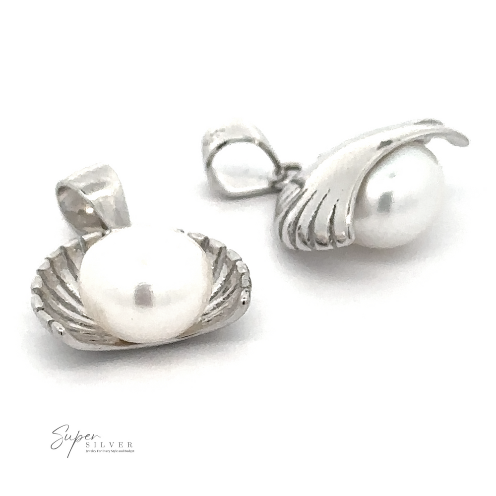 
                  
                    Two sterling silver pendants shaped like petite half shells each hold a fresh water pearl, with one pendant fully open and the other slightly closed. The text "Pearl Pendant with Shell Background" is visible in the bottom left corner.
                  
                