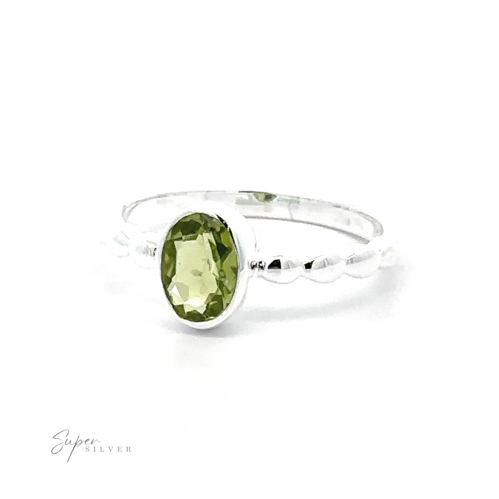 
                  
                    A silver Oval Gemstone Ring with Beaded Band featuring a green oval gemstone set in a simple, twisted band, against a white background.
                  
                