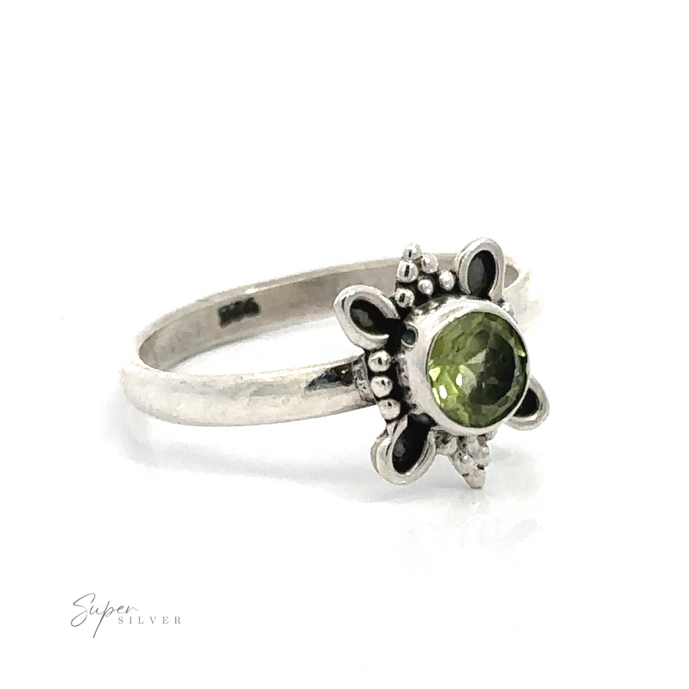
                  
                    Round Faceted Gemstone Ring with Ball and Loop Design with a green gemstone centerpiece and floral detailing on the band.
                  
                