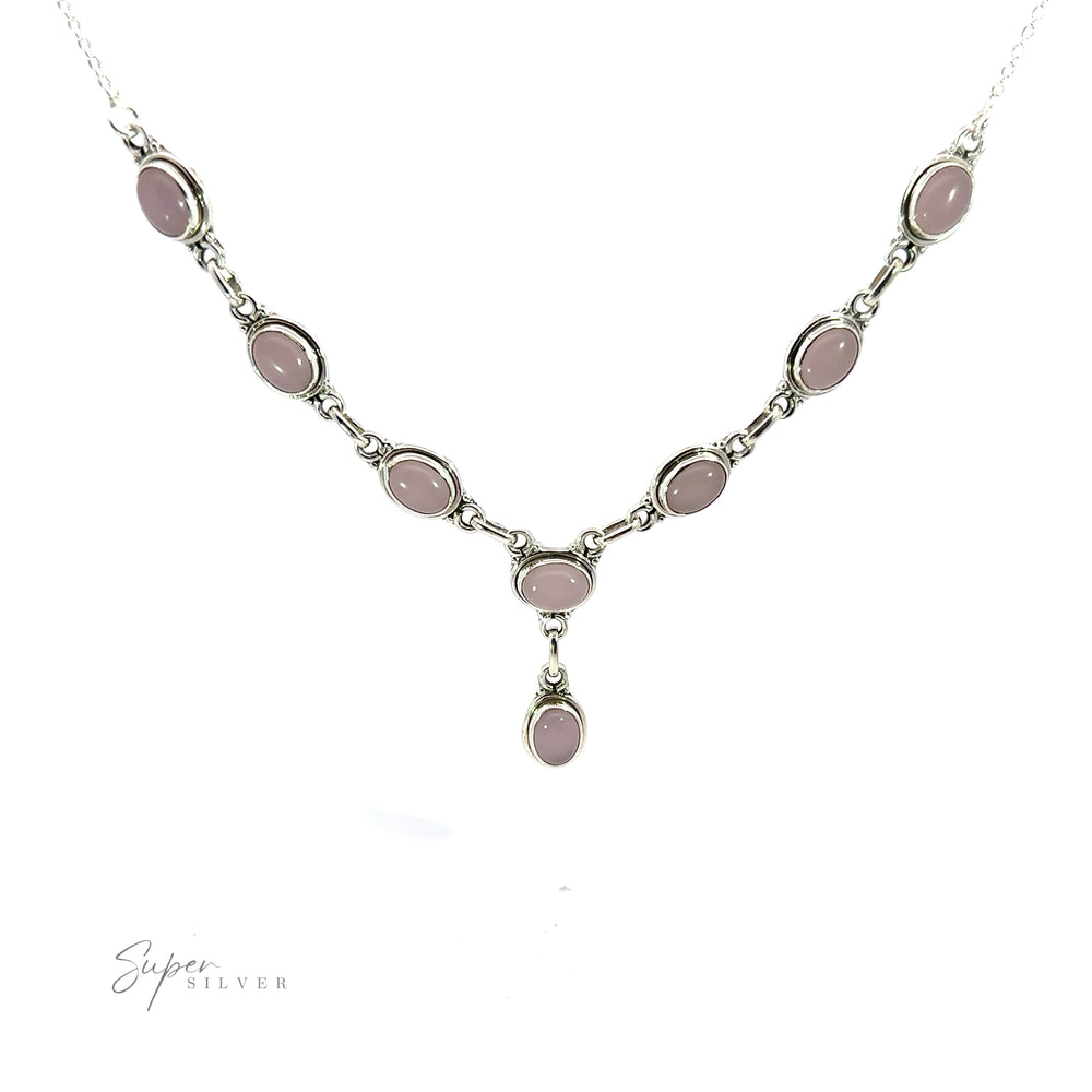
                  
                    A Simple Oval Y Necklace with Gemstones featuring oval-shaped pink gemstones, with a single dangling pink gemstone at the center. The necklace exudes bohemian charm and is displayed on a plain white background.
                  
                