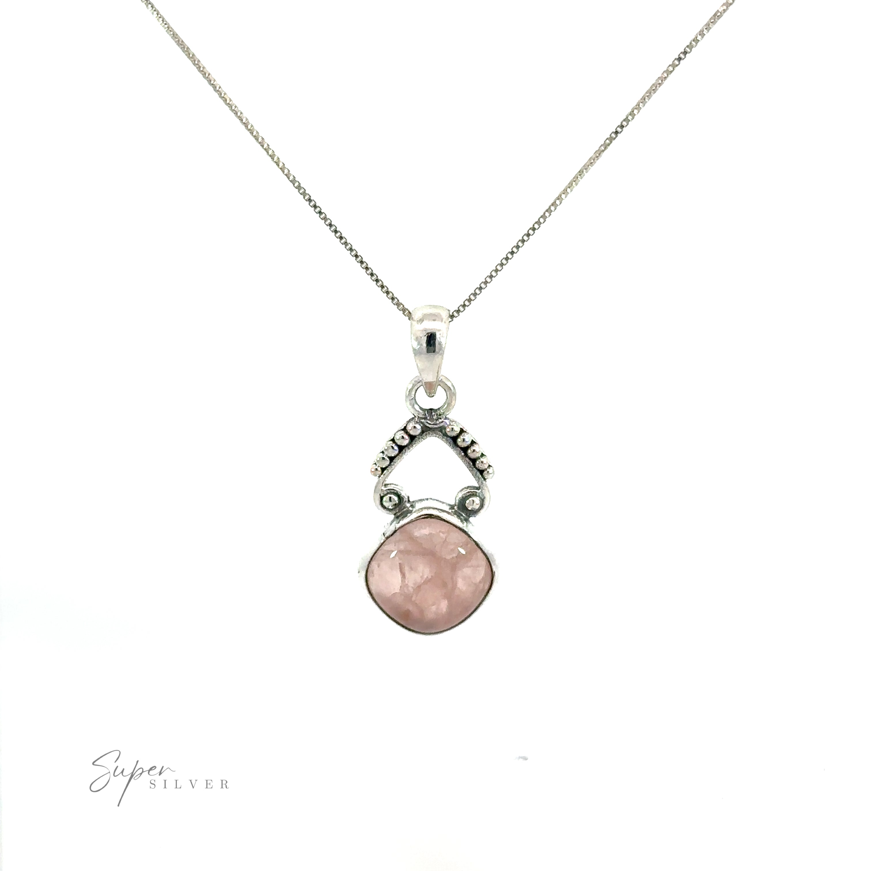 A bohemian-inspired diamond shaped gemstone pendant on a silver chain, adorned with gemstones.