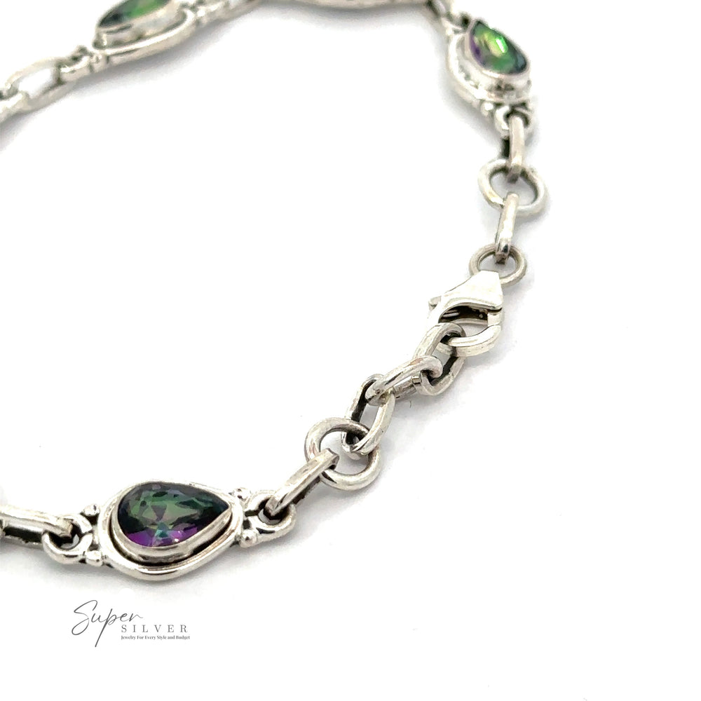 
                  
                    A close-up of a sterling silver bracelet with oval-shaped, multicolored gemstones set in ornate links. The bracelet features a clasp for fastening. The text "Super Silver" is visible in the corner, highlighting this exquisite Rainbow Topaz Bordered Teardrop Bracelet.
                  
                