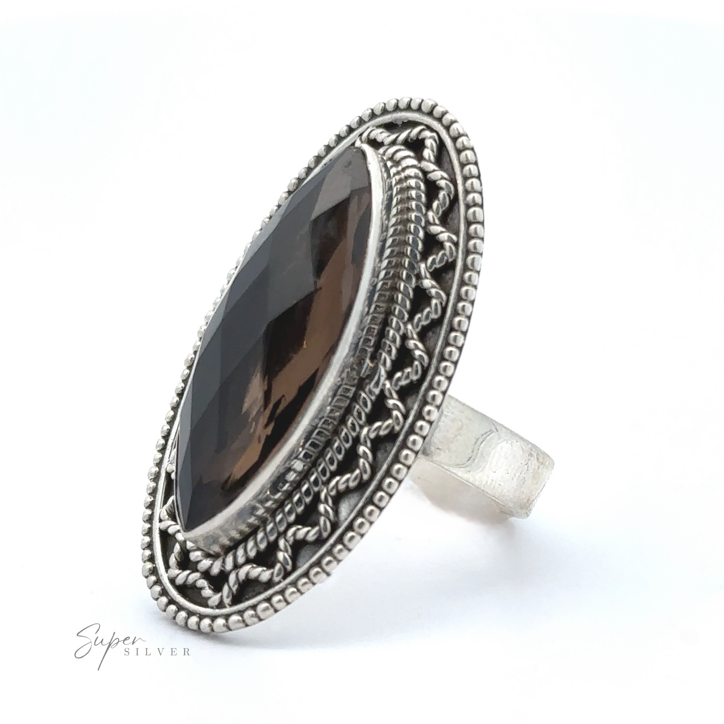 
                  
                    A Marquise Shaped Gemstone Ring With Vintage Shield Border featuring a large marquise-cut dark gemstone, surrounded by intricate detailing on the band, giving it a Bohemian twist.
                  
                