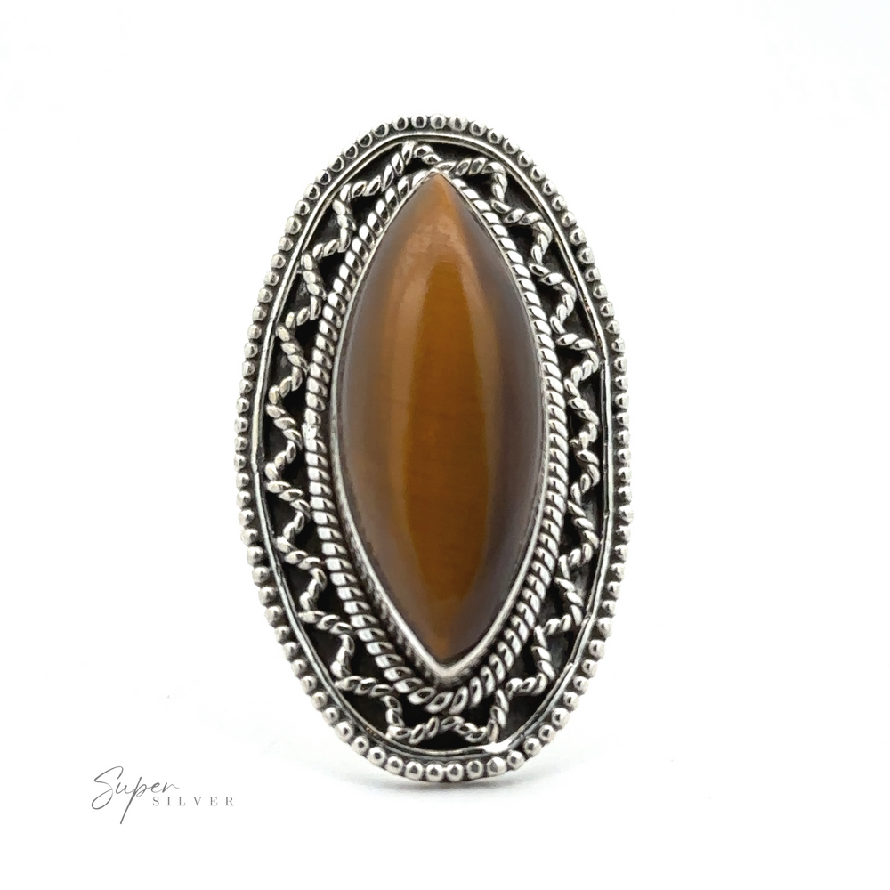 
                  
                    An intricately designed Marquise Shaped Gemstone Ring With Vintage Shield Border featuring an elongated oval brown stone at its center, set against a white background, with a Bohemian twist adding to its unique charm.
                  
                