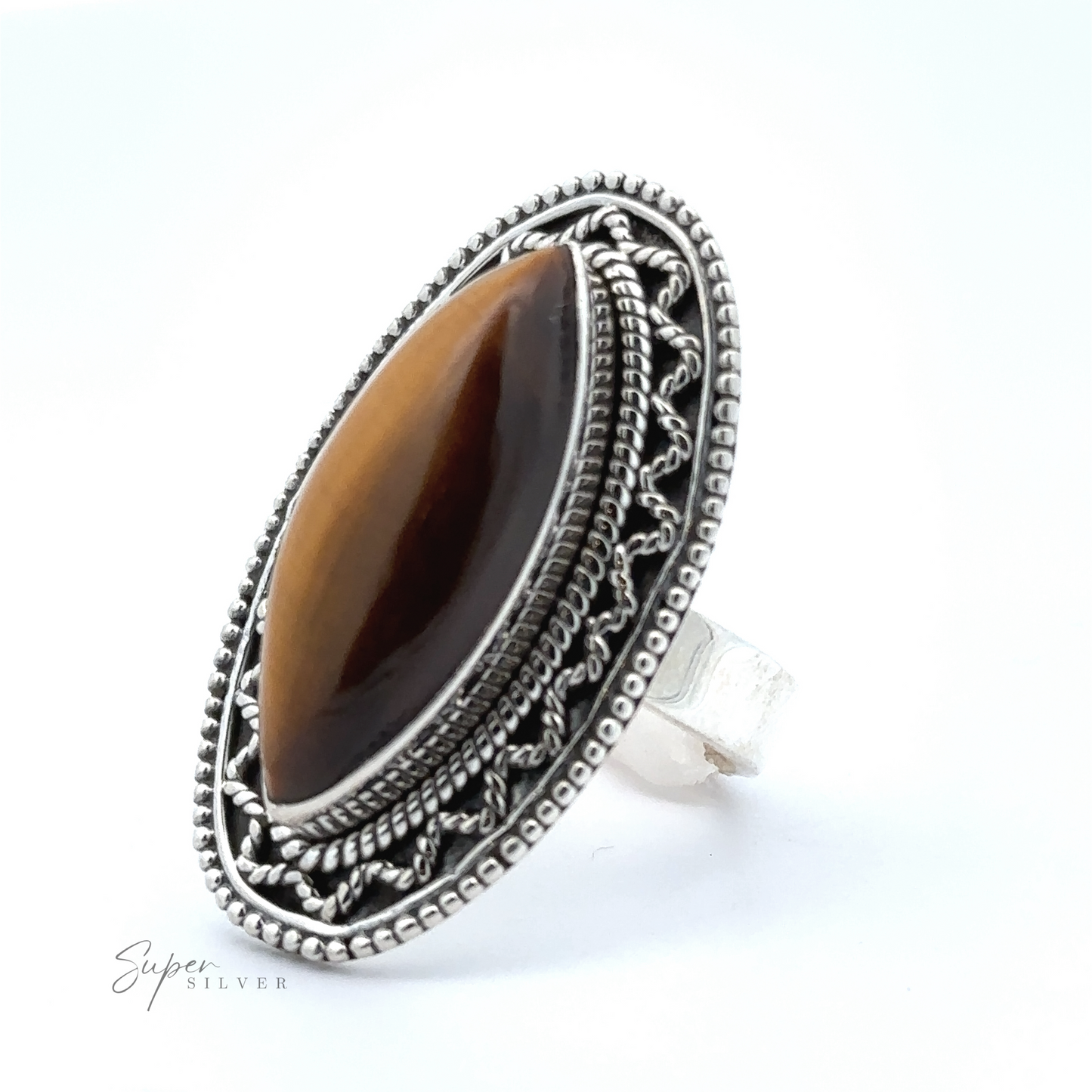 
                  
                    A marquise shaped gemstone ring with vintage shield border, featuring an oval-shaped brown gemstone in the center. The ring, marked "Super Silver," exudes a subtle bohemian twist.
                  
                