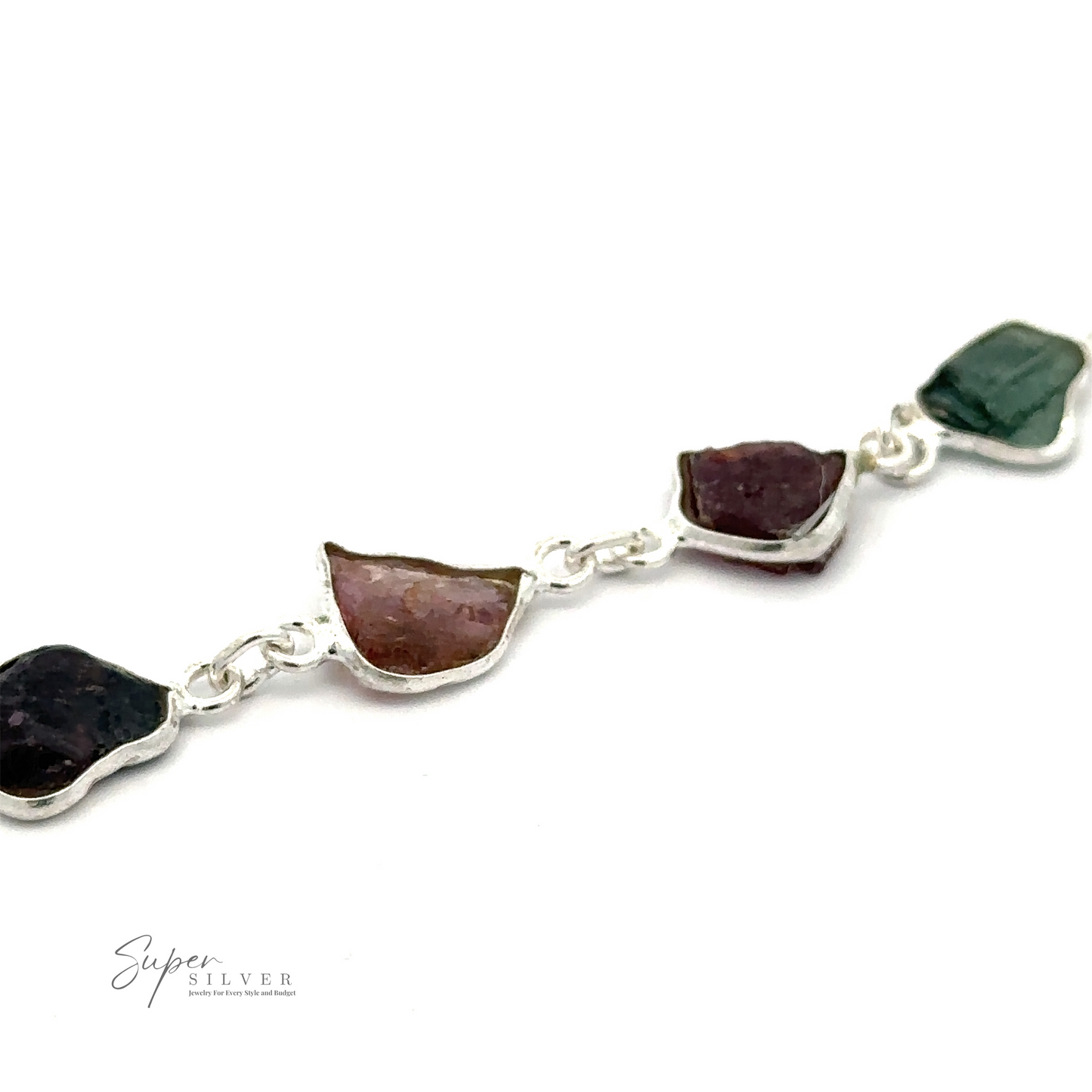 
                  
                    A Rough Tourmaline Bracelet featuring irregularly shaped, earthy elegance with multicolored rough tourmaline stones linked together. The stones vary in shades of green, purple, and pink. The logo "Super Silver" is visible in the bottom left corner.
                  
                