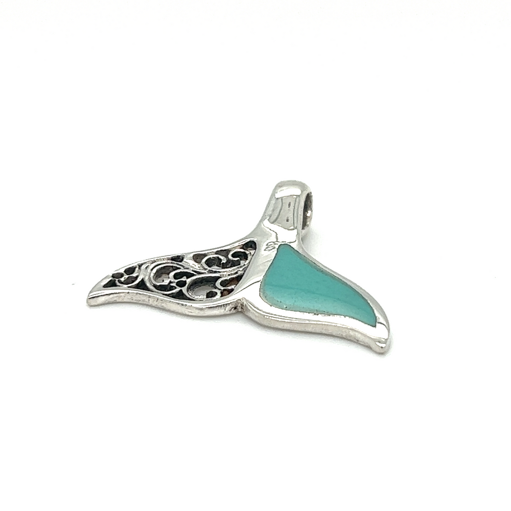 
                  
                    A Half Filigree Whale Tail Pendant adorned with turquoise accents, perfect for ocean conservation enthusiasts and supporters of Oceana.
                  
                