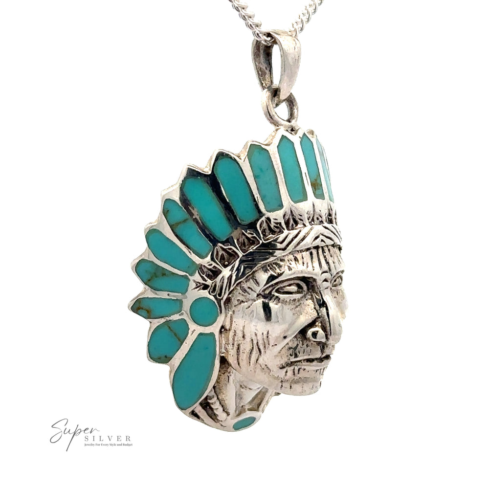 
                  
                    A statement piece, this Chief Pendant With Inlaid Stones features a detailed face adorned with a blue and silver headdress, enhanced by Abalone Turquoise, and elegantly suspended from a silver chain.
                  
                
