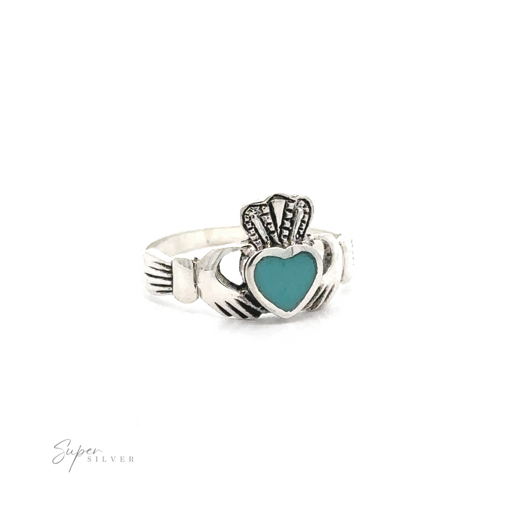 
                  
                    Claddagh Inlaid Stone Ring with a turquoise heart, representing Irish heritage, displayed on a plain white background with a "super silver" signature.
                  
                